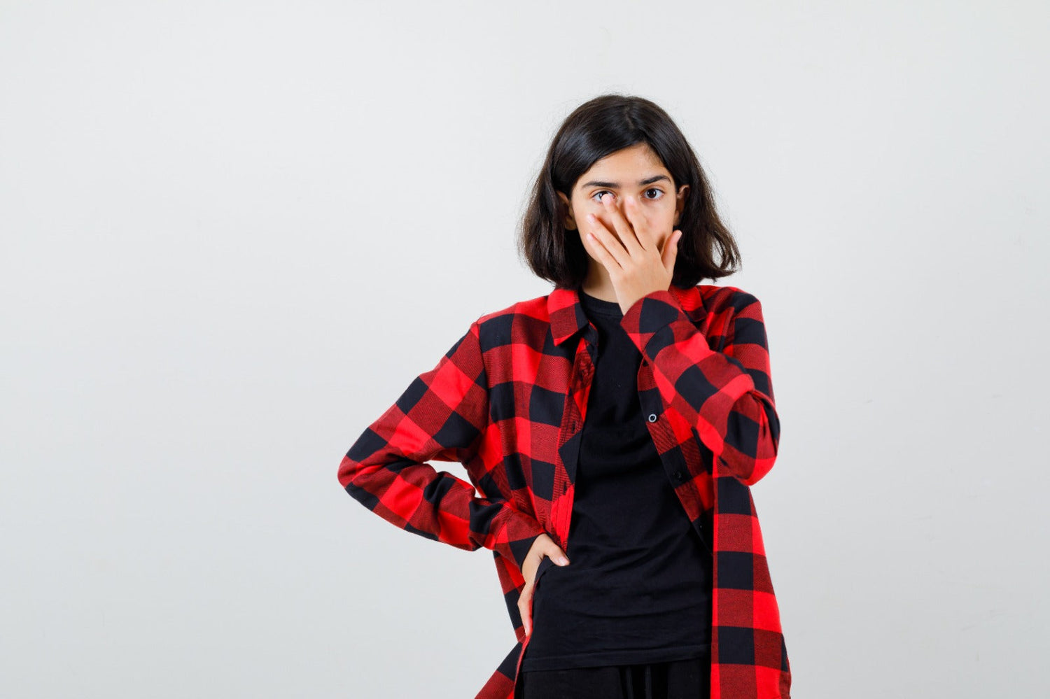 Teen girl holding hand on mouth
